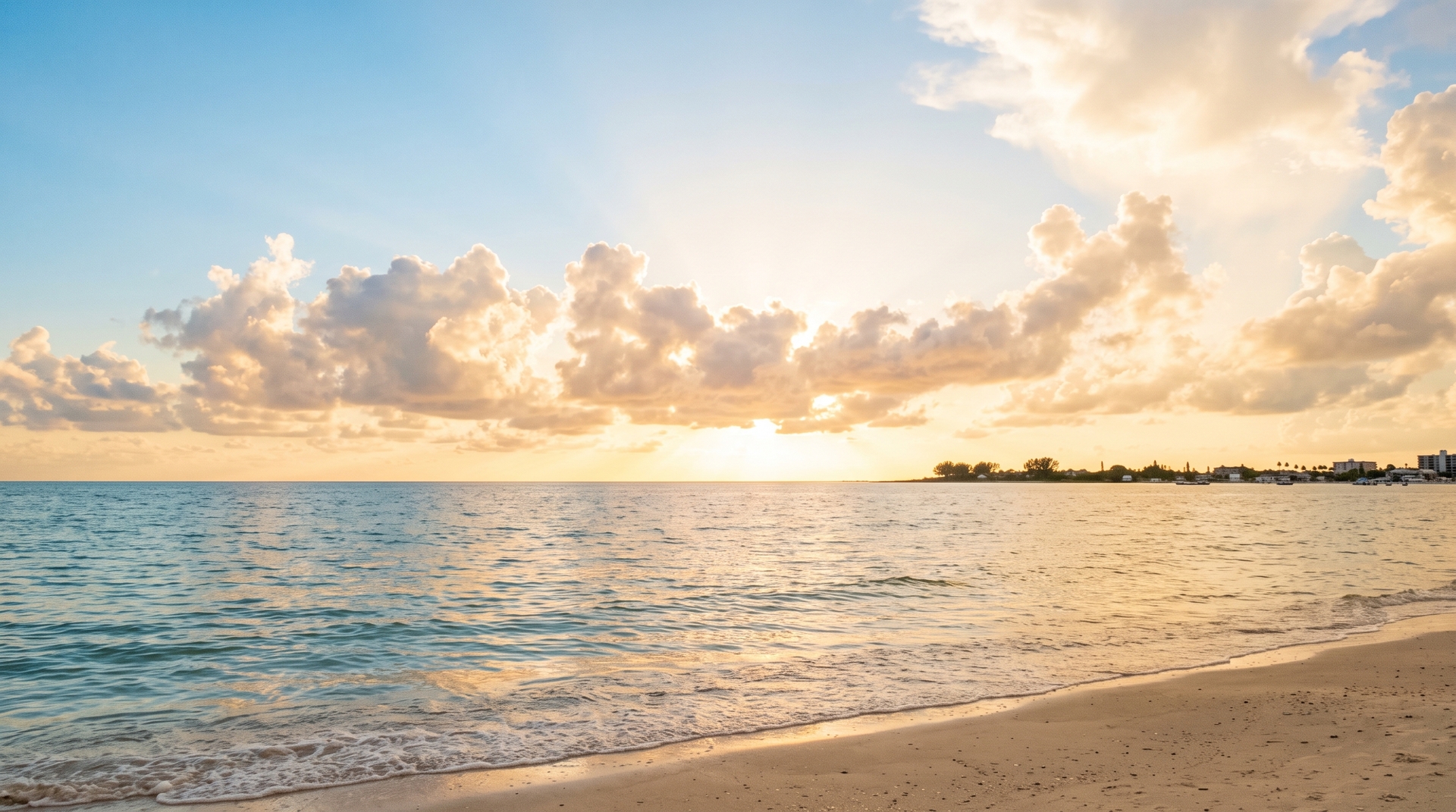 Gold-edged clouds and a burst of sunlight over a calm Gulf of Mexico horizon
